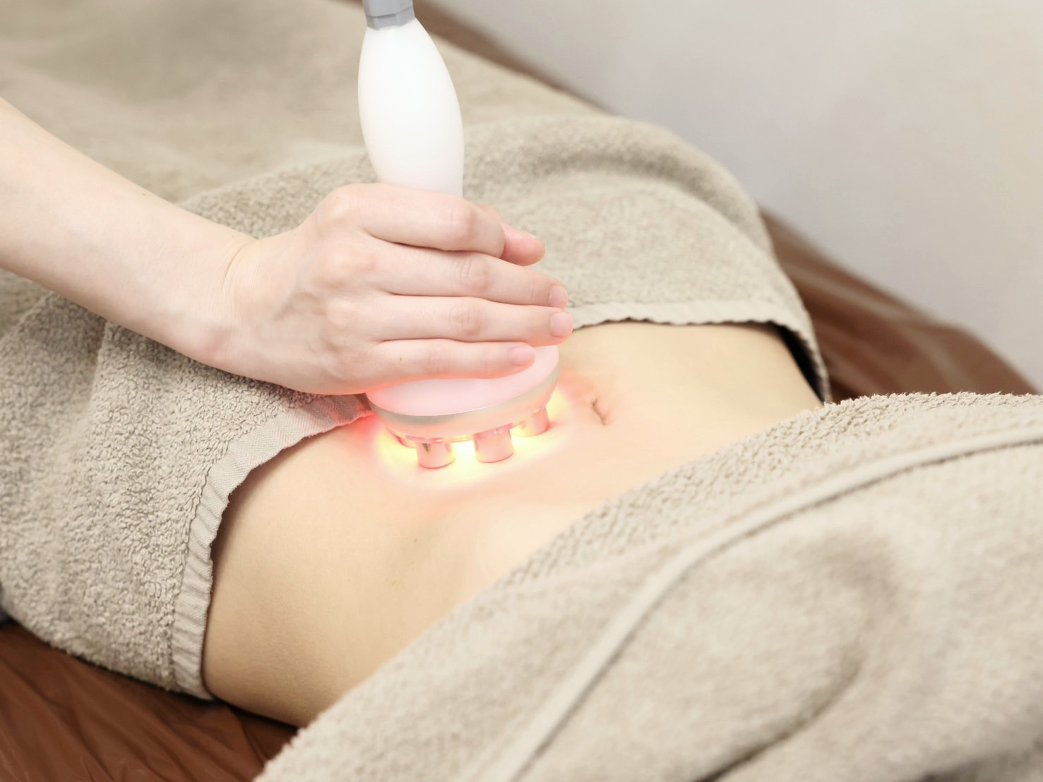 RUA BODY施術の様子。お腹に美容機器を当てているシーン
